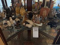 Overall view of glass cabinet shelf showing majority of decorative items