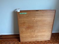 Wood underside of square table top 35 x 35 inches with legs stacked beside