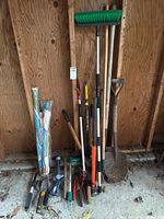 Group of all tools and kites leaning against garage wall