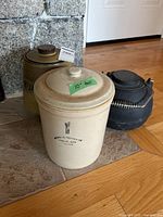 Front view showing Medalta crock, stoneware jug, cast iron kettle