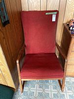 Front view of chair showing red cushions and wooden arms