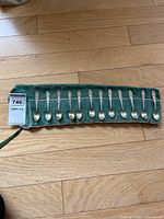All twelve sterling teaspoons in green felt roll, MaxSold tag visible