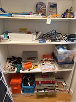 Shelves showing bin toolboxes, drill, flashlight, storage boxes