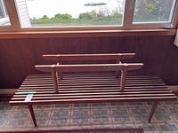 Large slatted bench with small bench frame placed on top