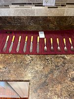 Full set of knives and forks laid out in fabric roll