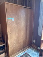 Front view of wooden wardrobe showing sliding doors and recessed pulls