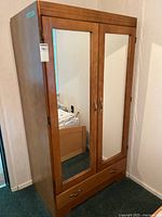 Full view of wardrobe showing mirrored doors and drawer