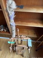 Full view of wooden spinning wheel showing treadle, wheel and distaff