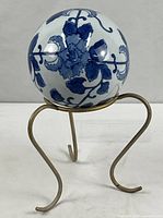 Full view of porcelain sphere on stand