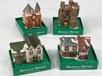 group shot of all four porcelain Dickens’ Village ornaments on green bases
