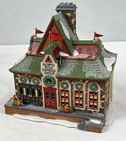 Front angled view of North Pole Express Depot building showing roof, flags and snow detailing