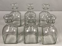 Six clear square glass bottles with stoppers displayed front view