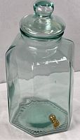 Full view of hexagonal green glass dispenser with lid