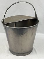 Full view of stainless steel pail, handle raised