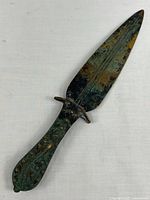 Full view of bronze dagger on light backdrop