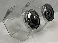 Both glass canisters angled showing lids and body shape