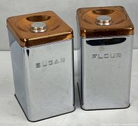 Both chrome canisters side by side showing Sugar and Flour labels