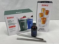 Group shot of all boxed items, syrup bottle and metal straws