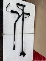 both black adjustable canes on table