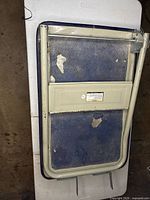 Cooler lid standing upright showing underside with folded legs and Coleman logo