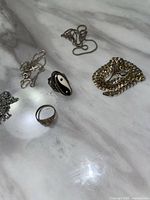 five sterling silver jewelry pieces on marble surface