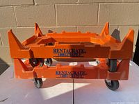 Two orange Rentacrate dollies stacked on table