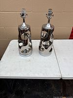 Front view of both chrome cut-out table lamp bases