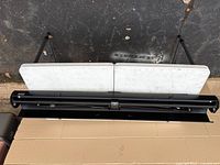 Screen in folded position inside black metal floor case