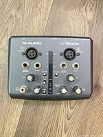 Top view showing M-Audio M-Track branding, combo inputs, knobs and switches