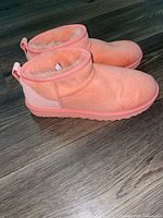 Side view of both UGG ankle boots showing suede exterior and rubber sole