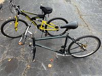 Two bicycles; front dark green Schwinn Frontier without front wheel