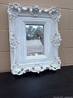 Front view of white ornate Rococo-style wall mirror