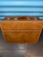 front view of tan suitcase with accent stripe