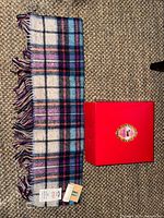 Full view of wool scarf beside red Avoca box