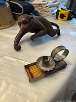 Yixing monkey figurine and metal match holder on table