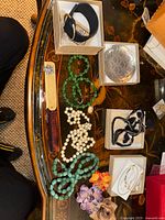 Overview of bead necklaces, bracelets, earrings, trinket dish and accessories on table