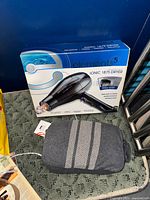 Boxed Element 5 Ionic 1875 hair dryer beside zippered travel blanket pouch