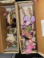 Both figurines in open boxes showing costumes and accessories
