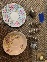 Overview showing Foley saucer, Royal Albert plate, Dansk elephant, six silver shakers, one porcelain shaker
