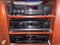 Stacked Sony audio components inside cabinet