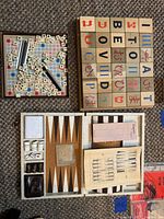 Top view of Scrabble set, M&Co. alphabet blocks and backgammon case open with pieces
