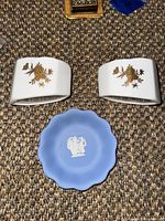 Top view showing two porcelain spoon rests with gold floral design and blue Wedgwood jasperware dish