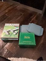 Pick Two Deluxe box beside Battleship peg grids and Trivial Pursuit box