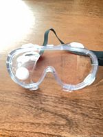 unwrapped clear safety goggles showing lens and strap