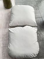 Two white vegan leather cushions displayed on floor