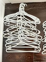 Stack of white plastic hangers showing overall quantity and style