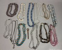 All necklaces and pin arranged on tabletop