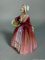 Front angled view of Royal Doulton Janet figurine showing gown colors and basket