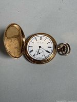 Open pocket watch showing dial and case interior