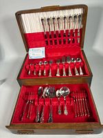 Open two-tier chest showing full flatware set